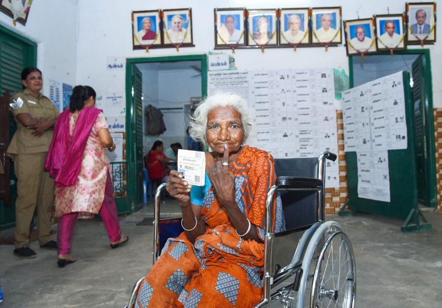 An elderly woman voter showing mark of indelible ink after casting her vote, at a polling booth in Chennai